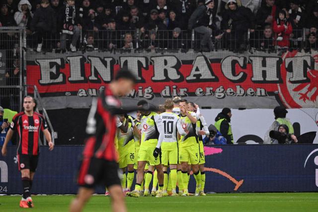 Dortmund's German forward #14 Maximilian Beier (R) celebrates scoring the opening goal with his teammates during the German first division Bundesliga football match between Eintracht Frankfurt and BVB Borussia Dortmund in Frankfurt am Main, western Germany, on January 9, 2026. (Photo by Kirill KUDRYAVTSEV / AFP) / DFL REGULATIONS PROHIBIT ANY USE OF PHOTOGRAPHS AS IMAGE SEQUENCES AND/OR QUASI-VIDEO