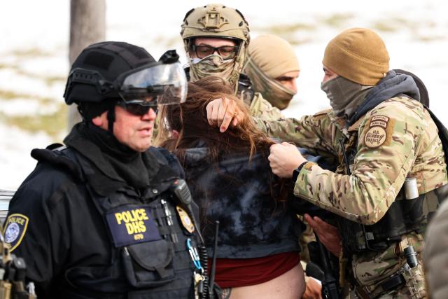 Federal agents detain a protester near the Bishop Henry Whipple Federal Building in Minneapolis, Minnesota, on January 9, 2026. A US Immigration and Customs Enforcement (ICE) agent shot and killed an American woman on the streets of Minneapolis January 7, leading to huge protests and outrage from local leaders who rejected White House claims she was a domestic terrorist. The woman, identified in local media as 37-year-old Renee Nicole Good, was hit at point blank range as she apparently tried to drive away from agents who were crowding around her car, which they said was blocking their way. (Photo by CHARLY TRIBALLEAU / AFP)