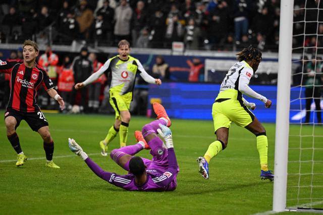 Dortmund's English midfielder #17 Carney Chukwuemeka (R) celebrates scoring the 3-3 goal past Frankfurt's Brazilian goalkeeper #40 Kaua Santos (C) during the German first division Bundesliga football match between Eintracht Frankfurt and BVB Borussia Dortmund in Frankfurt am Main, western Germany, on January 9, 2026. (Photo by Kirill KUDRYAVTSEV / AFP) / DFL REGULATIONS PROHIBIT ANY USE OF PHOTOGRAPHS AS IMAGE SEQUENCES AND/OR QUASI-VIDEO