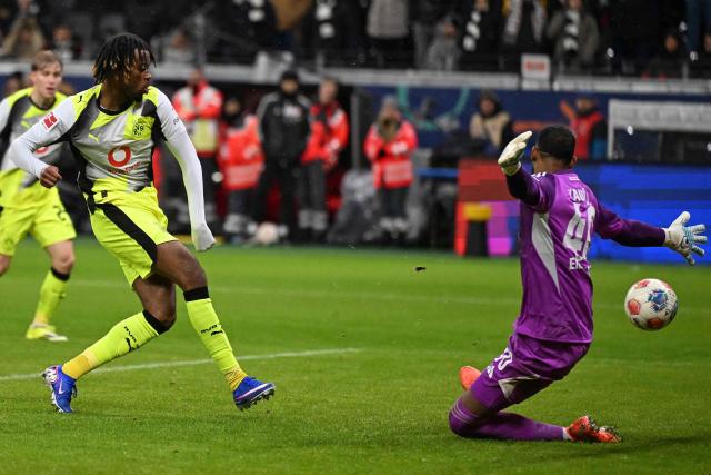 Dortmund's English midfielder #17 Carney Chukwuemeka (L) scores the 3-3 goal past Frankfurt's Brazilian goalkeeper #40 Kaua Santos (R) during the German first division Bundesliga football match between Eintracht Frankfurt and BVB Borussia Dortmund in Frankfurt am Main, western Germany, on January 9, 2026. (Photo by Kirill KUDRYAVTSEV / AFP) / DFL REGULATIONS PROHIBIT ANY USE OF PHOTOGRAPHS AS IMAGE SEQUENCES AND/OR QUASI-VIDEO