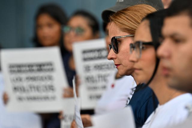 A woman looks on during a demonstration by relatives of political prisoners in demand of the release of their loved ones, near the notorious El Helicoide -a facility and prison owned by the Venezuelan government and used for both regular and political prisoners of the Bolivarian National Intelligence Service (SEBIN)- in Caracas on January 9, 2026. Venezuela began releasing a "large number" of political prisoners, including several foreigners, in a move praised by US President Donald Trump on January 9 as a step toward cooperation after the ouster of ruler Nicolas Maduro. (Photo by Juan BARRETO / AFP)