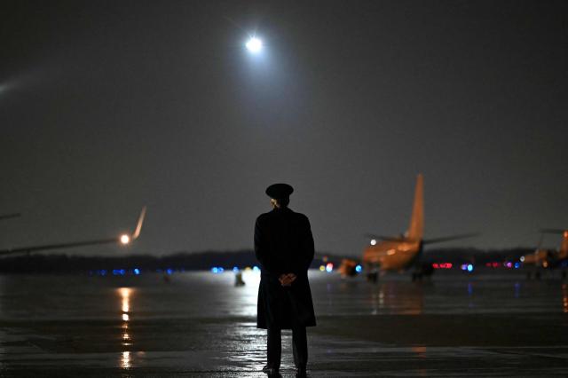 A main greeter waits for the arrival of US President Donald Trump at Joint Base Andrews, Maryland on January 9, 2026. Trump is traveling to Mar-a-Lago for the weekend. (Photo by ANDREW CABALLERO-REYNOLDS / AFP)