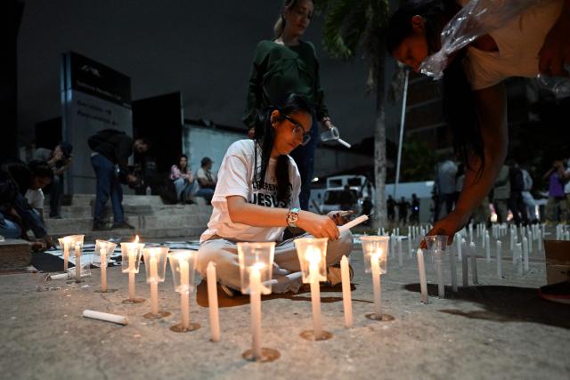 Relatives of political prisoners light candles in a vigil in demand of the release of their loved ones, near the notorious El Helicoide -a facility and prison owned by the Venezuelan government and used for both regular and political prisoners of the Bolivarian National Intelligence Service (SEBIN)- in Caracas on January 9, 2026. Venezuela began releasing a "large number" of political prisoners, including several foreigners, in a move praised by US President Donald Trump on January 9 as a step toward cooperation after the ouster of ruler Nicolas Maduro. (Photo by Juan BARRETO / AFP)