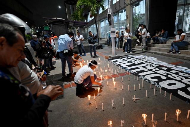 Relatives of political prisoners light candles in a vigil in demand of the release of their loved ones, near the notorious El Helicoide -a facility and prison owned by the Venezuelan government and used for both regular and political prisoners of the Bolivarian National Intelligence Service (SEBIN)- in Caracas on January 9, 2026. Venezuela began releasing a "large number" of political prisoners, including several foreigners, in a move praised by US President Donald Trump on January 9 as a step toward cooperation after the ouster of ruler Nicolas Maduro. (Photo by Juan BARRETO / AFP)