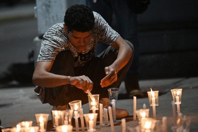 A young men lights a candle during a vigil by relatives of political prisoners in demand of the release of their loved ones, near the notorious El Helicoide -a facility and prison owned by the Venezuelan government and used for both regular and political prisoners of the Bolivarian National Intelligence Service (SEBIN)- in Caracas on January 9, 2026. Venezuela began releasing a "large number" of political prisoners, including several foreigners, in a move praised by US President Donald Trump on January 9 as a step toward cooperation after the ouster of ruler Nicolas Maduro. (Photo by Juan BARRETO / AFP)