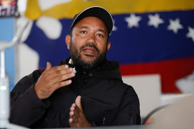 Willians, a member of 'Boina Roja,' a pro-government group known as 'Colectivos,' gestures as he speaks during an interview with AFP in Caracas on January 6, 2025. When explosions boomed in the night and US warplanes roared in the sky over Caracas, Jorge Suarez and his companions rushed fearfully for their guns. For these members of the "Colectivos" -- armed loyalists of the leftist leadership -- the US raid that ousted Nicolas Maduro as their president was the most dramatic challenge yet. (Photo by Pedro MATTEY / AFP)