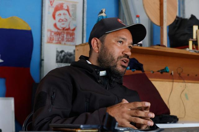 Willians, a member of 'Boina Roja,' a pro-government group known as 'Colectivos,' gestures as he speaks during an interview with AFP in Caracas on January 6, 2025. When explosions boomed in the night and US warplanes roared in the sky over Caracas, Jorge Suarez and his companions rushed fearfully for their guns. For these members of the "Colectivos" -- armed loyalists of the leftist leadership -- the US raid that ousted Nicolas Maduro as their president was the most dramatic challenge yet. (Photo by Pedro MATTEY / AFP)