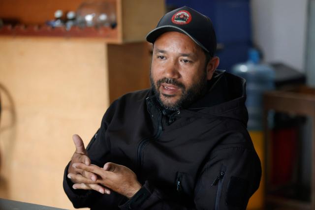 Willians, a member of 'Boina Roja,' a pro-government group known as 'Colectivos,' gestures as he speaks during an interview with AFP in Caracas on January 6, 2025. When explosions boomed in the night and US warplanes roared in the sky over Caracas, Jorge Suarez and his companions rushed fearfully for their guns. For these members of the "Colectivos" -- armed loyalists of the leftist leadership -- the US raid that ousted Nicolas Maduro as their president was the most dramatic challenge yet. (Photo by Pedro MATTEY / AFP)