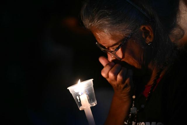 An elderly woman gestures during a vigil by relatives of political prisoners in demand of the release of their loved ones outside of El Rodeo I prison in Guatire, Miranda State, some 30 kilometers east of Caracas on January 9, 2026. Venezuela on January 8 began releasing a "large number" of political prisoners, including several foreigners, in a move praised by US President Donald Trump as a step toward cooperation after the ouster of ruler Nicolas Maduro. (Photo by RONALDO SCHEMIDT / AFP)