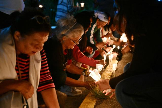 Relatives of political prisoners light candles during a vigil in demand of the release of their loved ones outside of El Rodeo I prison in Guatire, Miranda State, some 30 kilometers east of Caracas on January 9, 2026. Venezuela on January 8 began releasing a "large number" of political prisoners, including several foreigners, in a move praised by US President Donald Trump as a step toward cooperation after the ouster of ruler Nicolas Maduro. (Photo by RONALDO SCHEMIDT / AFP)