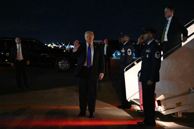 TOPSHOT - US President Donald Trump waves after stepping off Air Force One upon arrival at Palm Beach International Airport in West Palm Beach, Florida on January 9, 2026. President Trump is in Florida to spend the week-end at his Mar-a-Lago estate. (Photo by ANDREW CABALLERO-REYNOLDS / AFP)