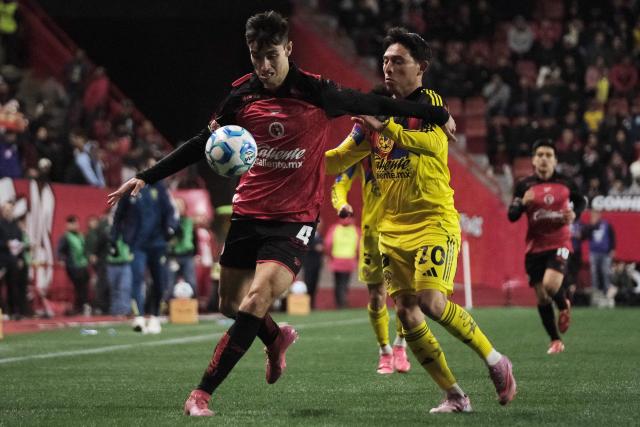 Tijuana's Spanish defender #04 Unai Bilbao and America's midfielder #20 Alexis Gutierrez fight for the ball during the Liga MX Clausura tournament football match between Tijuana and America at Caliente Stadium in Tijuana, Baja California, Mexico on January 9, 2026. (Photo by Guillermo Arias / AFP)