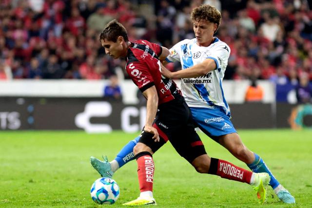 Atlas' defender #15 Paulo Ramirez AND Puebla's midfielder #24 Alejandro Organista fight for the ball during the Liga MX Clausura football match between Atlas and Puebla at Jalisco Stadium in Guadalajara, Jalisco state, Mexico on January 9, 2026. (Photo by Ulises Ruiz / AFP)