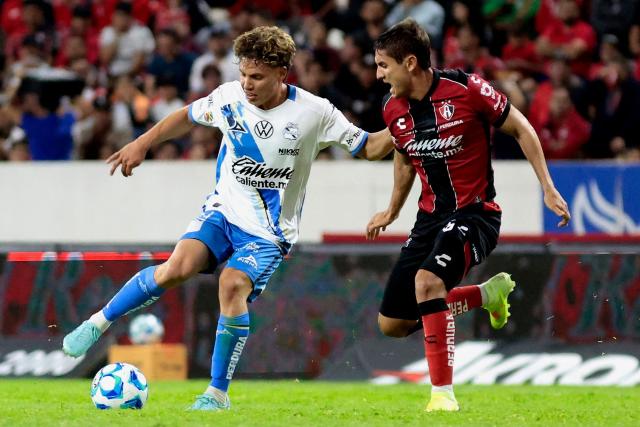 Puebla's midfielder #24 Alejandro Organista and Atlas' defender #15 Paulo Ramirez fight for the ball during the Liga MX Clausura football match between Atlas and Puebla at Jalisco Stadium in Guadalajara, Jalisco state, Mexico on January 9, 2026. (Photo by Ulises Ruiz / AFP)