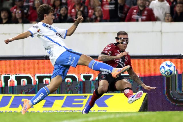 Puebla's midfielder #12 Iker Moreno and Atlas' Brazilian forward #03 Gustavo Ferrareis fight for the ball during the Liga MX Clausura football match between Atlas and Puebla at Jalisco Stadium in Guadalajara, Jalisco state, Mexico on January 9, 2026. (Photo by Ulises Ruiz / AFP)
