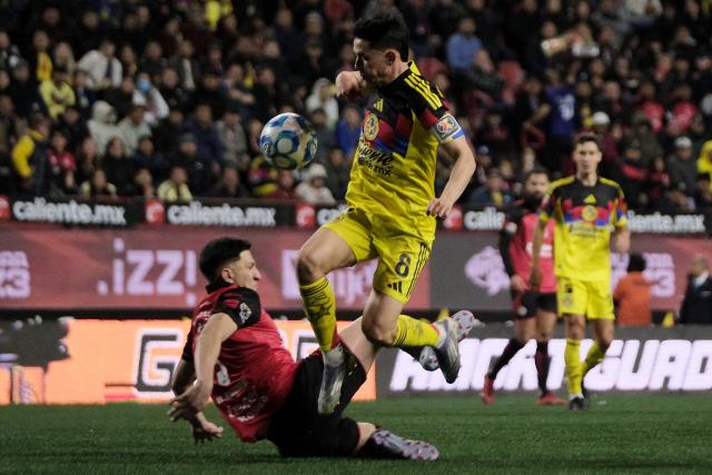 Tijuana's Uruguayan midfielder #22 Ignacio Rivero and America's Spanish midfielder #08 Alvaro Fidalgo fight for the ball during the Liga MX Clausura tournament football match between Tijuana and America at Caliente Stadium in Tijuana, Baja California, Mexico on January 9, 2026. (Photo by Guillermo Arias / AFP)