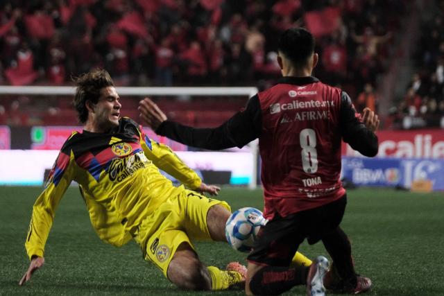 America's forward #33 Patricio Salas and Tijuana's midfielder #08 Ivan Tona fight for the ball during the Liga MX Clausura tournament football match between Tijuana and America at Caliente Stadium in Tijuana, Baja California, Mexico on January 9, 2026. (Photo by Guillermo Arias / AFP)