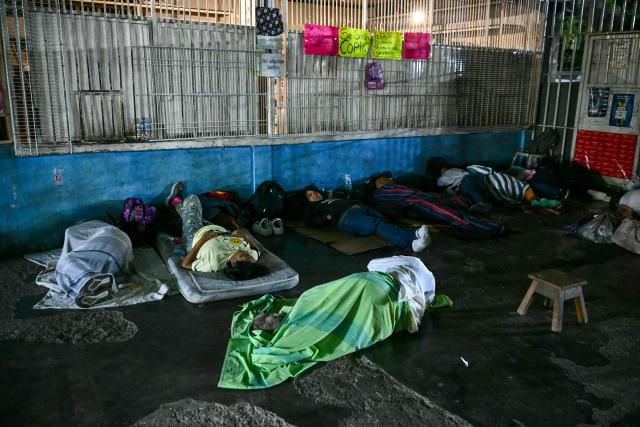 Relatives of political prisoners sleep in the foyer of a shop adjacent to El Rodeo I prison as they wait for their release  in Guatire, Miranda State, some 30 kilometers east of Caracas on January 10, 2026. Venezuela on January 8 began releasing a "large number" of political prisoners, including several foreigners, in a move praised by US President Donald Trump as a step toward cooperation after the ouster of ruler Nicolas Maduro. (Photo by RONALDO SCHEMIDT / AFP)