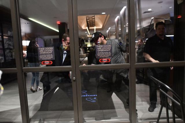 Employees shut the front entrance of a hotel to keep protesters outside as they march in protest against ICE after the fatal shooting of Renee Nicole Good in downtown Minneapolis, Minnesota on January 9, 2026. A US Immigration and Customs Enforcement (ICE) agent shot and killed 37-year-old Renee Nicole Good on the streets of Minneapolis on January 7, leading to huge protests and outrage from local leaders who rejected White House claims she was a domestic terrorist. (Photo by Octavio JONES / AFP)