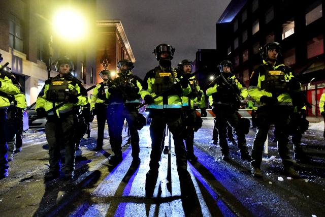 Minnesota Conservation Officers stand in formation as protesters were given the order to disperse after marching in protest against ICE for the fatal shooting of Renee Nicole Good in downtown Minneapolis, Minnesota on January 9, 2026. A US Immigration and Customs Enforcement (ICE) agent shot and killed 37-year-old Renee Nicole Good on the streets of Minneapolis on January 7, leading to huge protests and outrage from local leaders who rejected White House claims she was a domestic terrorist. (Photo by Octavio JONES / AFP)