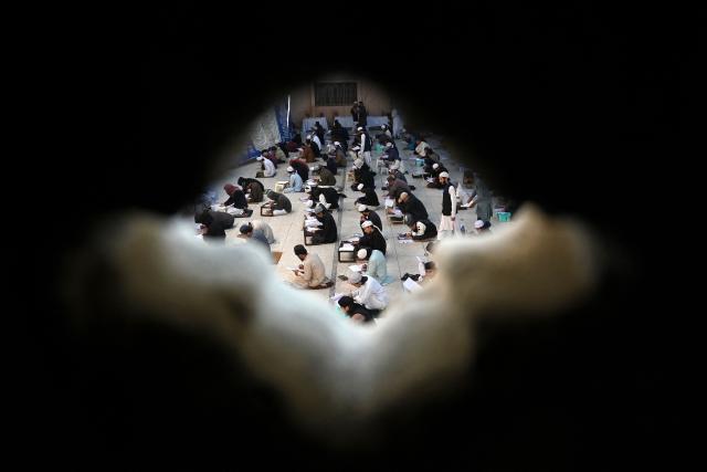 Students appear for their annual examination at the Islamic Jamia Binoria Aalamia seminary in Karachi on January 10, 2026. (Photo by Rizwan TABASSUM / AFP)