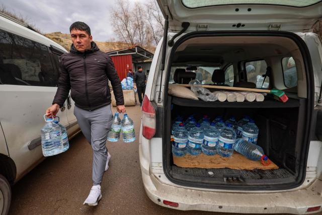 A man walks with empty containers to fetch water during water scarcity in the Araplar neighbourhood of the Mamaklar district in Ankara on January 8, 2026. Because of this shortage, some neighborhoods in Ankara are experiencing water cuts for several hours a day, and many residents are forced to wait in line at public fountains to fill their containers. (Photo by Adem ALTAN / AFP)