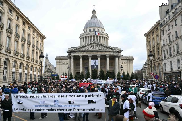 TOPSHOT - Demonstrators gather in front of the Pantheon during a protest called by private doctors to denounce an "authoritarian drift" in the healthcare system in Paris on January 10, 2026 as part of a strike from 5 till January 15. Independent physicians will march in Paris on January 10, 2026 afternoon at the call of all their unions to denounce an "authoritarian drift" in the healthcare system, in the words of one of the participating organisations, the Jeunes Médecins union. (Photo by Bertrand GUAY / AFP)