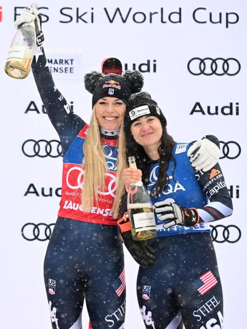 Winner US' Lindsey Vonn (L) and third placed US' Jacqueline Wiles hold sparkling wine as they stand on the podium after the Women's Downhill event of the FIS Alpine Ski World Cup in Altenmarkt Zauchensee, Austria, on January 10, 2026. (Photo by BARBARA GINDL / APA / AFP) / Austria OUT