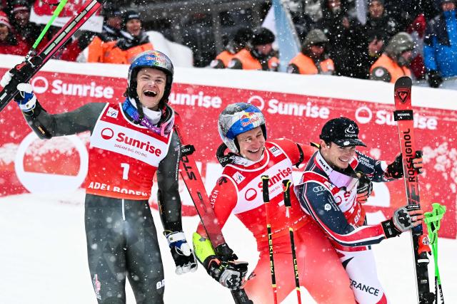 (From L) Second-placed Brazil's Lucas Pinheiro Braathen, first-placed Switzerland's Marco Odermatt and third-placed France's Leo Anguenot celebrate after the second run of the Men's Giant Slalom, part of the FIS Alpine Ski World Cup 2025-2026 in Adelboden, soutwestern Switzerland on January 10, 2026. (Photo by Fabrice COFFRINI / AFP)