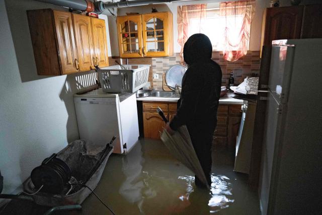 A man inspects his flooded house near the town of Lipjan on January 10, 2026, after torrential rains across Kosovo. (Photo by Armend NIMANI / AFP)