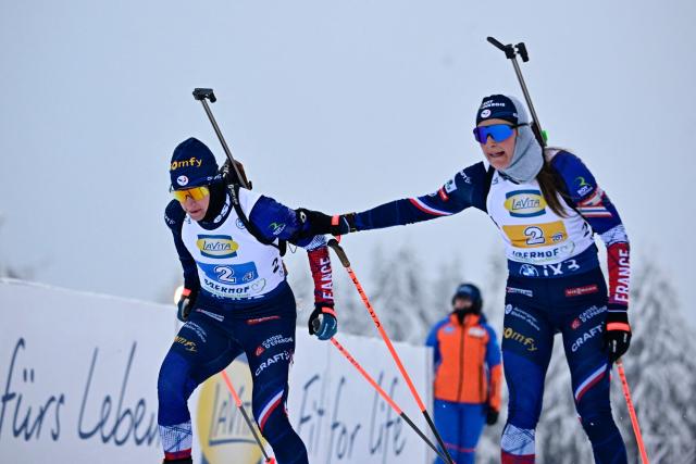 France's Justine Braisaz-Bouchet (R) hands over to France's Julia Simon during the women's 4x6km relay competition of the IBU Biathlon World Cup in Oberhof, eastern Germany on January 10, 2026. (Photo by Tobias SCHWARZ / AFP)