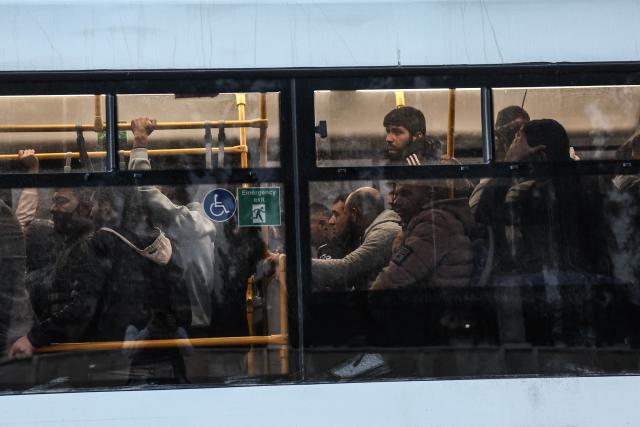 Kurdish fighters sit in a bus as they leave Aleppo's Kurdish-majority Sheikh Maqsud neighbourhood accompanied by security forces on January 10, 2026. Syrian authorities on January 10 began transferring Kurdish fighters from Aleppo's Sheikh Maqsud neighbourhood to the country's northeast, state television reported, after days of deadly clashes. (Photo by OMAR HAJ KADOUR / AFP)