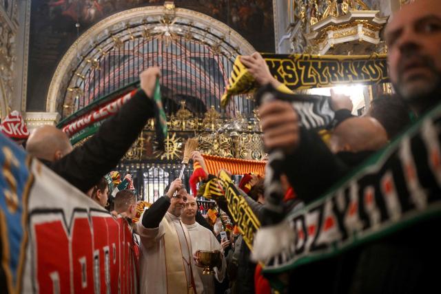 A priest blesses scarves of Polish football fans as they attend a holy mass during their annual pilgrimage at the Jasna Gora Monastery in Czestochowa on January 10, 2026. Polish football fans put aside their rivalries every year and gather at Poland’s holiest Catholic shrine the Jasna Gora Monastery in Czestochowa. (Photo by Sergei GAPON / AFP)