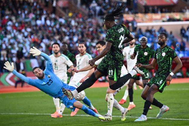 Nigeria's defender #21 Calvin Bassey fights for the ball as Algeria's goalkeeper #23 Luca Zidane dives during the Africa Cup of Nations (CAN) quarter-final football match between Algeria and Nigeria at the Grand stadium in Marrakesh on January 10, 2026. (Photo by Paul ELLIS / AFP)