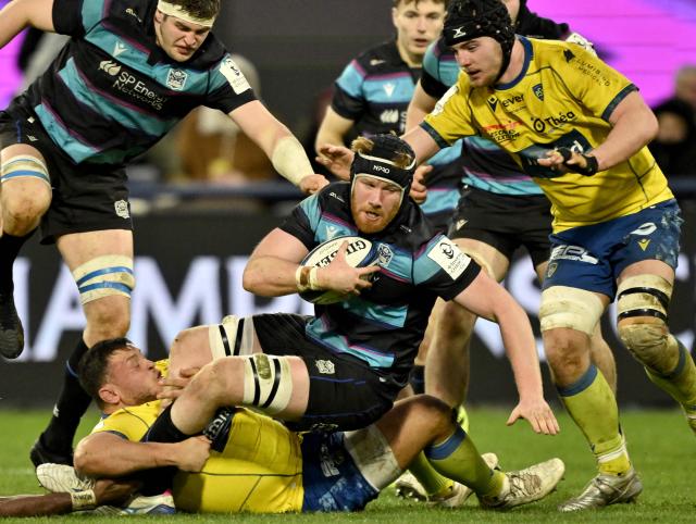 Glasgow's Scottish lock Gregor Brown (C) is tackled by Clermont's Fidjian center Pio Muarua and Clermont's French lock Thibault Lanen (R) during the European Champions Cup first round, day 3, pool 1, rugby union match between ASM Clermont Auvergne and Glasgow Warriors at the Marcel-Michelin Stadium in Clermont-Ferrand on January 10, 2026. (Photo by Jeff PACHOUD / AFP)