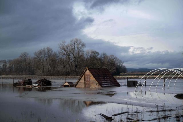 A flooded barn is seen in a field near the town of Lipjan on January 10, 2026, after torrential rains across Kosovo. (Photo by Armend NIMANI / AFP)