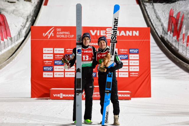Second placed Slovenia's Timi Zajc and (R) Slovenia's Anze Lanisek pose on the podium after the men's HS140 team event of the FIS Ski Jumping World Cup in Zakopane, Poland on January 10, 2026. Austria won the event ahead of Slovenia and Poland. (Photo by Wojtek RADWANSKI / AFP)