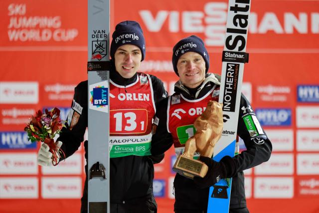 Second placed Slovenia's Timi Zajc and (R) Slovenia's Anze Lanisek pose on the podium after the men's HS140 team event of the FIS Ski Jumping World Cup in Zakopane, Poland on January 10, 2026. Austria won the event ahead of Slovenia and Poland. (Photo by Wojtek RADWANSKI / AFP)