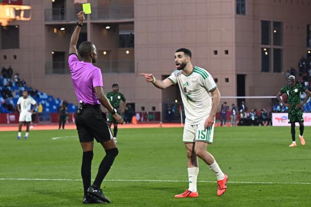 Senegalese referee Issa Sy shows a yellow card to Algeria's defender #15 Rayan Ait-Nouri during the Africa Cup of Nations (CAN) quarter-final football match between Algeria and Nigeria at the Grand stadium in Marrakesh on January 10, 2026. (Photo by Paul ELLIS / AFP)