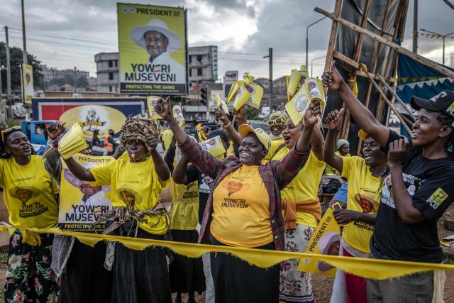 Supporters of Uganda’s incumbent president and National Resistance Movement (NRM) presidential candidate Yoweri Museveni dance while holding party flags as they campaign at a busy roundabout, ahead of the 2026 Ugandan general elections, in Kampala on January 10, 2026. (Photo by Luis TATO / AFP)