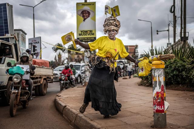 Efrance Nsudde, 50, campaigns for Uganda’s incumbent president and National Resistance Movement (NRM) presidential candidate Yoweri Museveni as she dances while holding party flags at a busy roundabout, ahead of the 2026 Ugandan general elections, in Kampala on January 10, 2026. (Photo by Luis TATO / AFP)