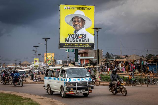 TOPSHOT - Residents travel past an electoral billboard supporting Uganda’s incumbent president and National Resistance Movement (NRM) presidential candidate Yoweri Museveni, ahead of the 2026 Ugandan general elections, in Kampala on January 10, 2026. (Photo by Luis TATO / AFP)