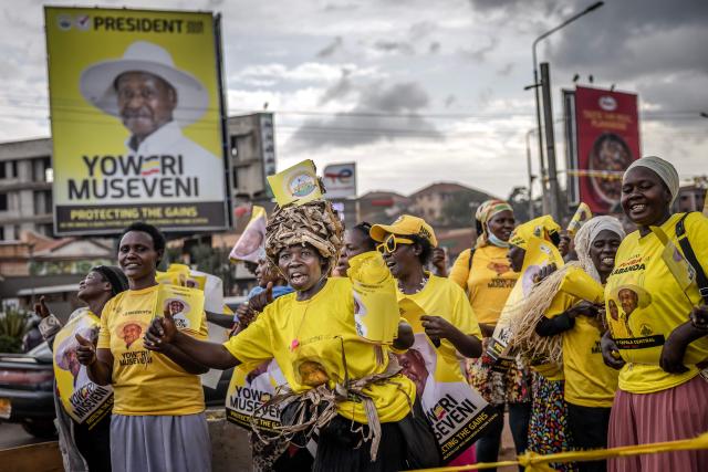 Supporters of Uganda’s incumbent president and National Resistance Movement (NRM) presidential candidate Yoweri Museveni dance while holding party flags as they campaign at a busy roundabout, ahead of the 2026 Ugandan general elections, in Kampala on January 10, 2026. (Photo by Luis TATO / AFP)