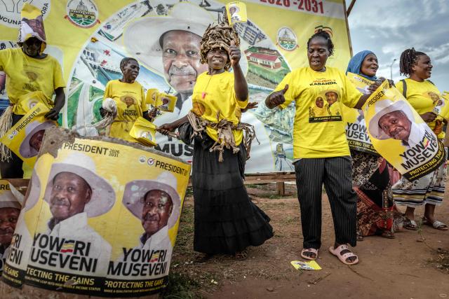 Supporters of Uganda’s incumbent president and National Resistance Movement (NRM) presidential candidate Yoweri Museveni dance while holding party flags as they campaign at a busy roundabout, ahead of the 2026 Ugandan general elections, in Kampala on January 10, 2026. (Photo by Luis TATO / AFP)