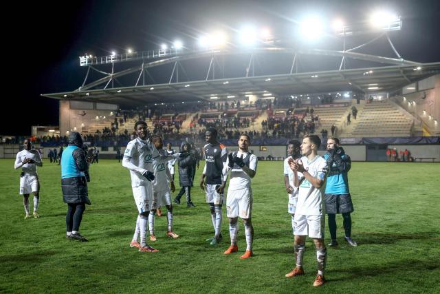 Lorient's players celebrate with supporters after winning the French Cup round of 32 football match between Hauts Lyonnais and FC Lorient at the Envol Stadium in Andrezieux-Bouthéon, central-eastern France, on January 10, 2026. (Photo by Alex MARTIN / AFP)