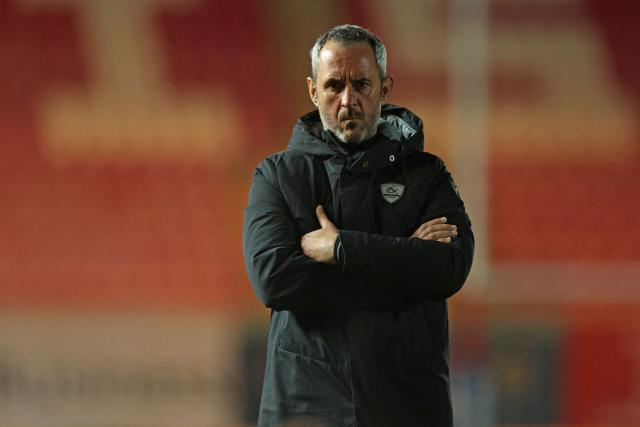Pau's French head coach Sebastien Piqueronies watches the warm-up ahead of the European Rugby Champions Cup pool 4 rugby union match between Scarlets and Section Paloise , Pau at Parc y Scarlets in Llanelli, south-west Wales on January 10, 2026. (Photo by Adrian Dennis / AFP)
