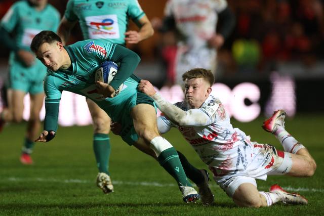 Pau's Clément Mondinat reaches runs to the line to score a try as Scarlets' Welsh scrum-half Archie Hughes (R) attempts a tackle during the European Rugby Champions Cup pool 4 rugby union match between Scarlets and Section Paloise , Pau at Parc y Scarlets in Llanelli, south-west Wales on January 10, 2026. (Photo by Adrian Dennis / AFP)