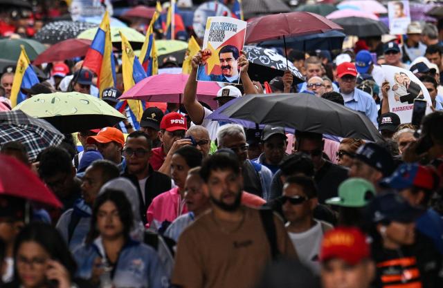 A demonstrator holds a picture of ousted Venezuela's President Nicolas Maduro during a rally in his support in Caracas on January 10, 2026. The US State Department on January 10, urged Americans in Venezuela to leave the country "immediately," citing risks from armed militias searching vehicles for US citizens at roadblocks. (Photo by Juan BARRETO / AFP)