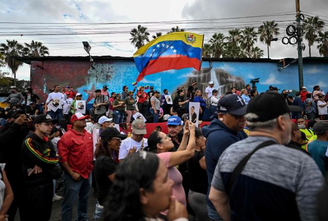 A demonstrator waves a Venezuelan flag during a rally in support of ousted Venezuela's President Nicolas Maduro in Caracas on January 10, 2026. The US State Department on January 10, urged Americans in Venezuela to leave the country "immediately," citing risks from armed militias searching vehicles for US citizens at roadblocks. (Photo by Juan BARRETO / AFP)