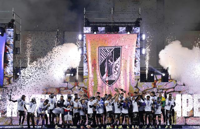 Vitoria Guimaraes's players celebrate with their trophy on the podium after winning the Portuguese Taca da Liga (League Cup) final football match between Vitoria SC and SC Braga at the Dr. Magalhaes Pessoa stadium in Leiria, on January 10, 2026. Vitoria Guimaraes won the finale 2-1. (Photo by FILIPE AMORIM / AFP)